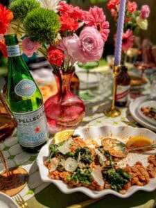 A table with a plate of food and a bottle of wine.