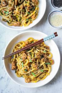 two bowls of noodles with chopsticks