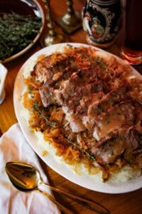 Sliced pork over sauerkraut and mashed potatoes topped with gravy