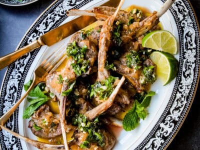 a plate of lamb rib chops with sauce