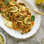 fish on a platter with lemons and sauce