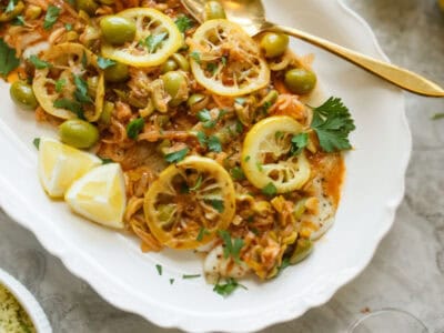 fish on a platter with lemons and sauce